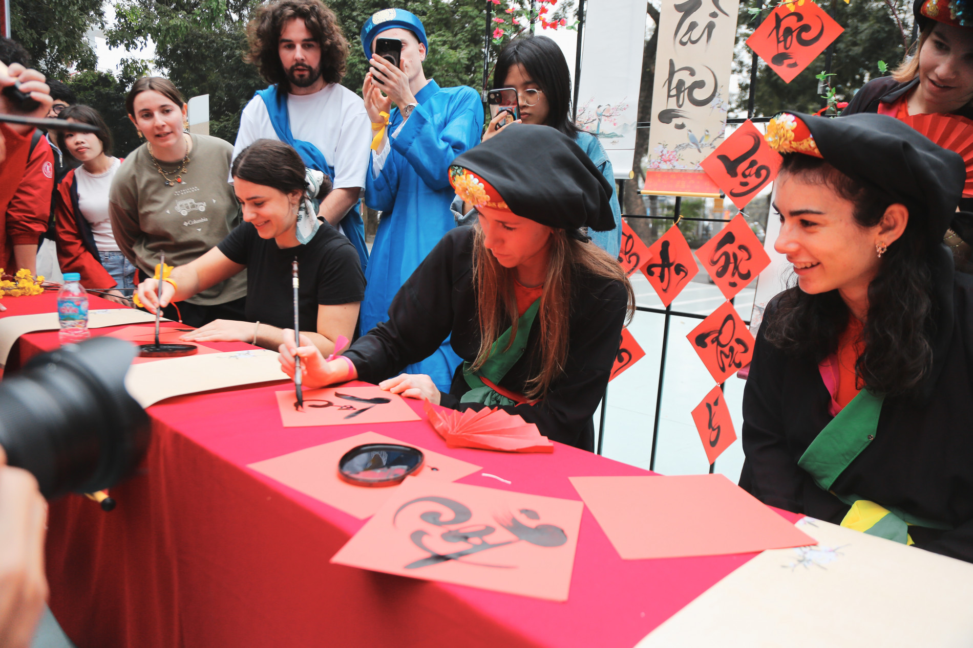 Khi Tết Việt Nam trở thành cầu nối văn hóa - Hình ảnh các bạn sinh viên viết thư pháp